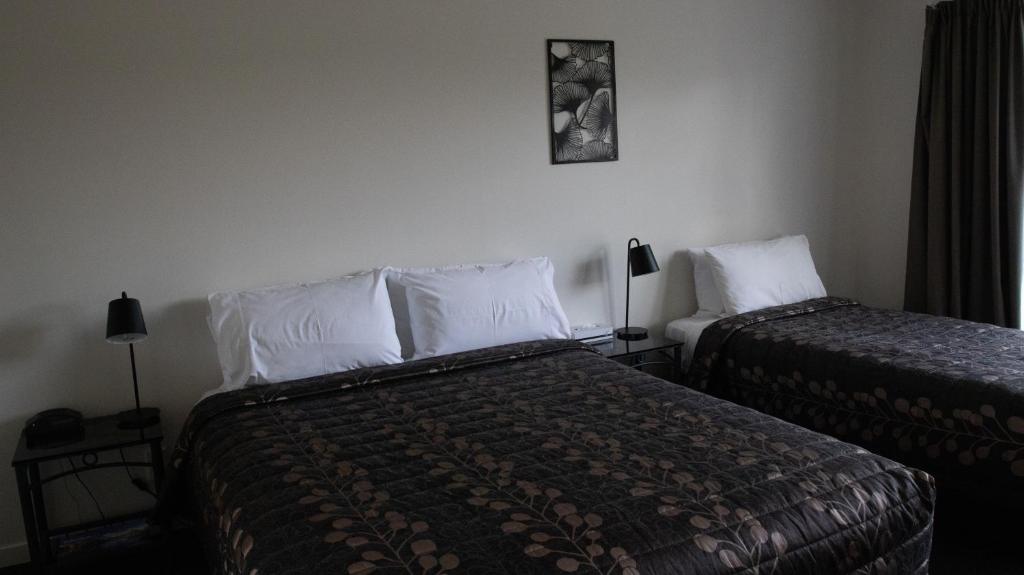 Postel nebo postele na pokoji v ubytování ASURE Phoenix Motor Inn