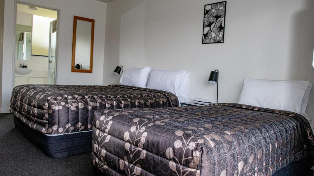 Postel nebo postele na pokoji v ubytování ASURE Phoenix Motor Inn