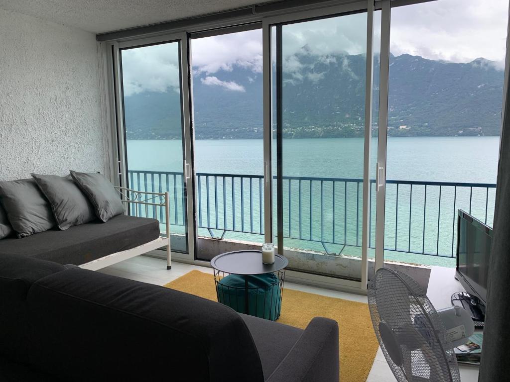 ein Wohnzimmer mit Blick auf das Wasser in der Unterkunft Le Lamartine, vue magnifique face au Lac du Bourget in Aix-les-Bains