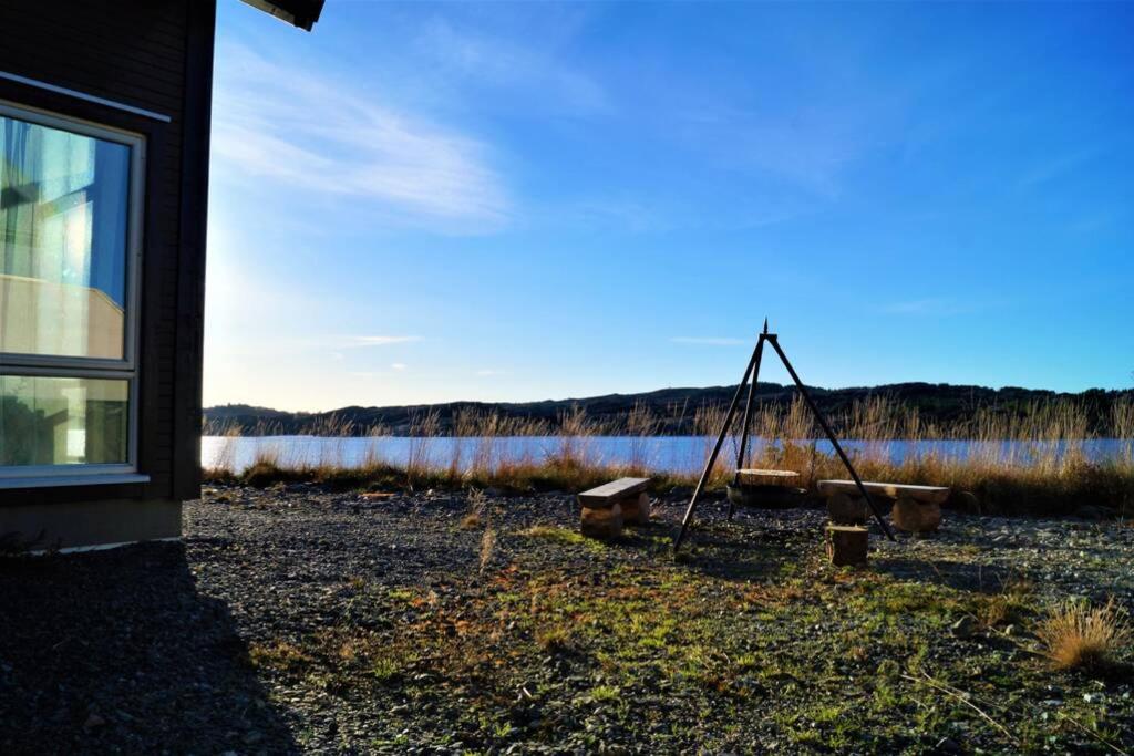 a view of a lake with a bench and a swing at Austefjordtunet 15 in Forland
