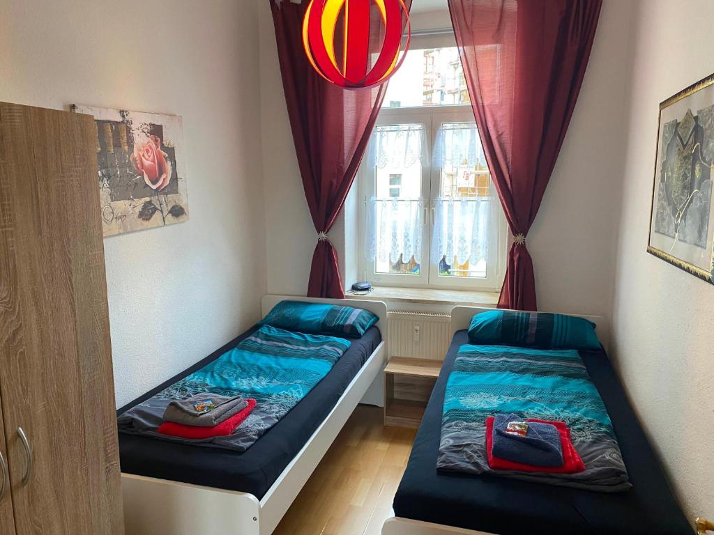 two beds in a small room with a window at Ferienwohnungen Plauen in Plauen