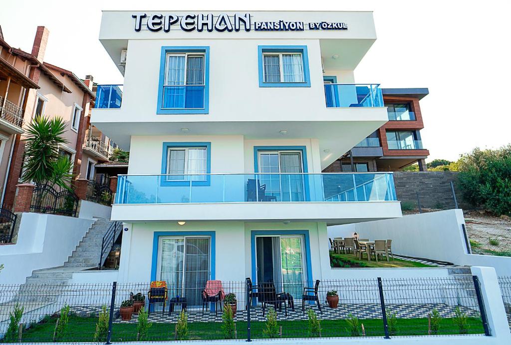 a white building with chairs and tables in front of it at Tepehan by Özkul in Izmir