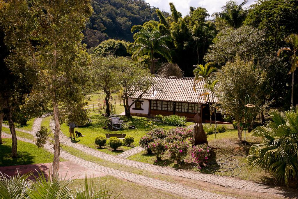 a person walking a dog in front of a house at Pouso do Bichinho 2 in Bichinho