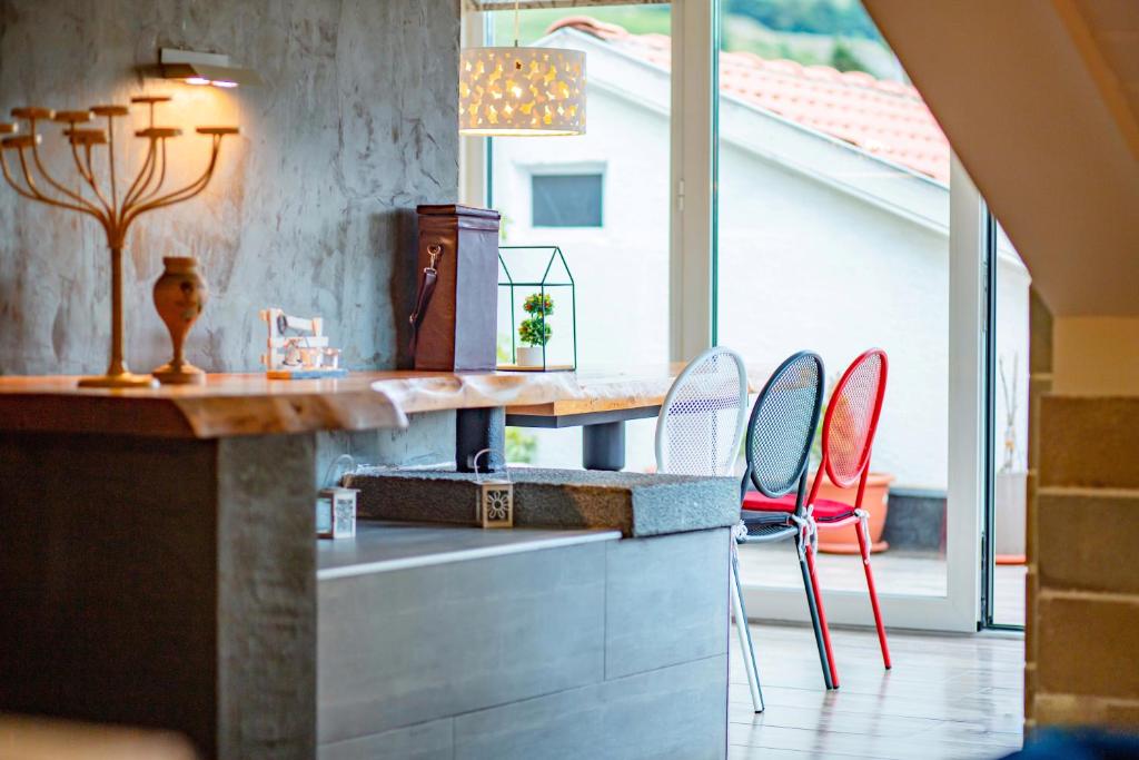 a kitchen with red chairs and a counter with a table at Meri Boutique Hotel in Korçë