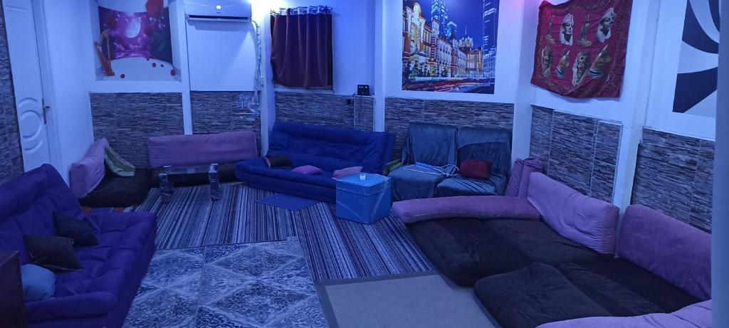uma sala de estar com sofás roxos e uma parede de tijolos em Aatun Roof Flat in Haram elevator and two floors stairs no Cairo