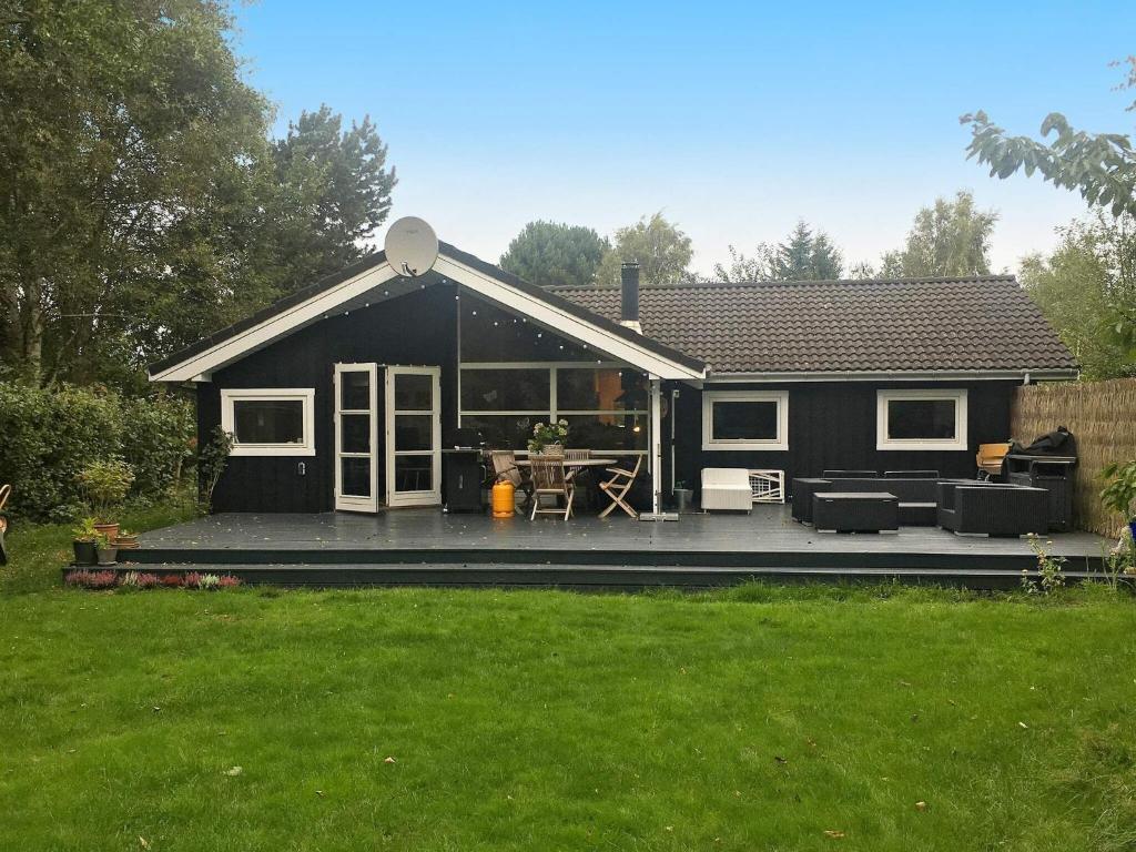 una casa nera con patio nel cortile di 8 person holiday home in Vejby a Vejby