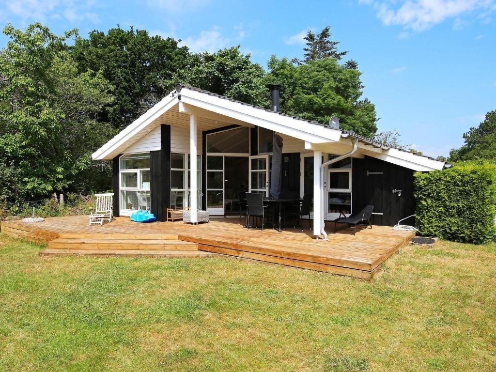 Casa pequeña con terraza de madera en un campo en 4 person holiday home in F llenslev, en Føllenslev