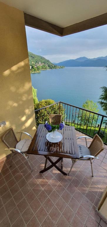 a table and chairs on a patio with a view of the water at Beautiful Place a Lago d'Orta mit direktem Seezugang in Omegna