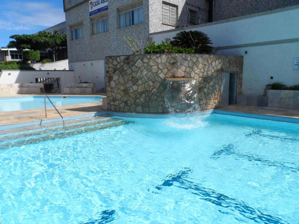 uma piscina com uma fonte num edifício em Casa Abel Hotel em Araruama
