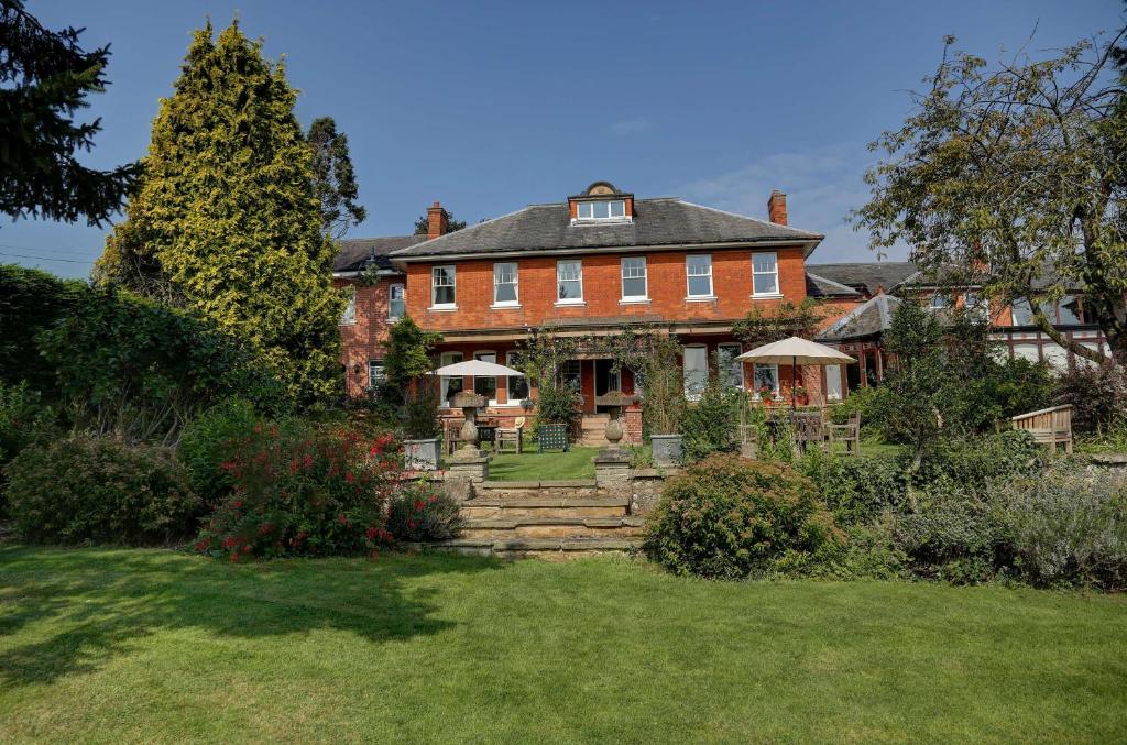 una gran casa de ladrillo rojo con patio en BEST WESTERN Sysonby Knoll en Melton Mowbray