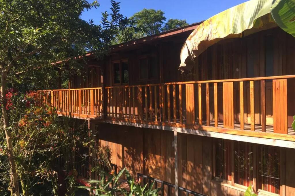 una terraza de madera en el lateral de una casa en Mindo cozy house, en Mindo