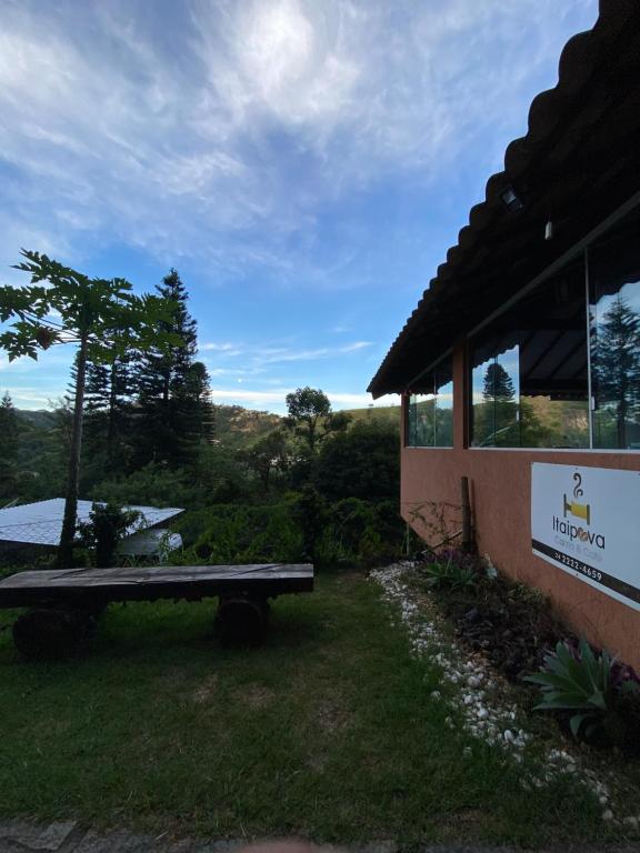 a picnic table in the grass next to a building at Itaipava Cama e Café in Itaipava