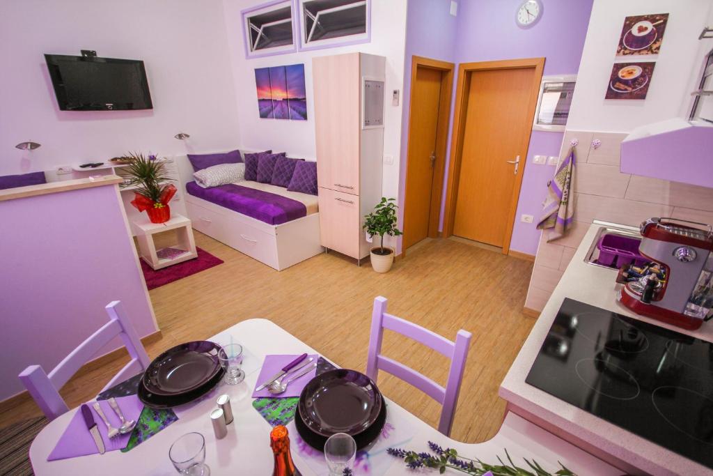 cocina y sala de estar con mesa y sillas. en Apartments Lavanda & Cappuccino, en Portorož