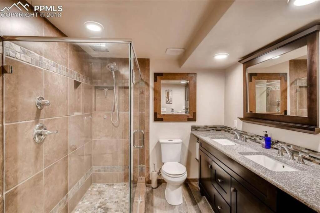 a bathroom with a shower and a toilet and a sink at 2 Master Suites/3 King Beds/4 Bath/Mins to Airport in Colorado Springs
