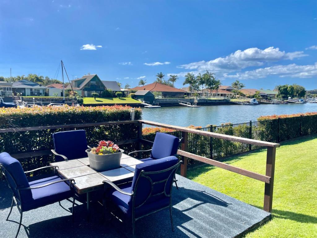 a patio with a table and chairs next to a river at Bribie Island Canal Holiday Destination! in Bongaree