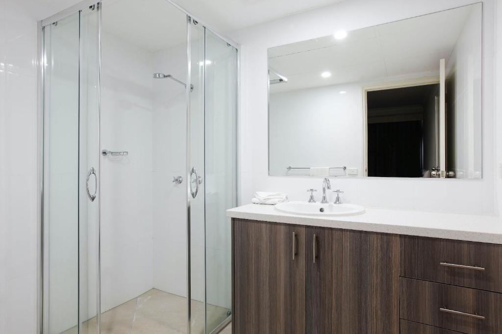 a bathroom with a sink and a glass shower at The Breakers in Gold Coast