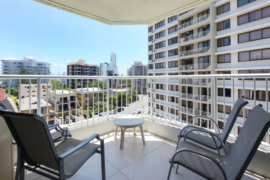 a balcony with chairs and a table and a building at The Breakers in Gold Coast