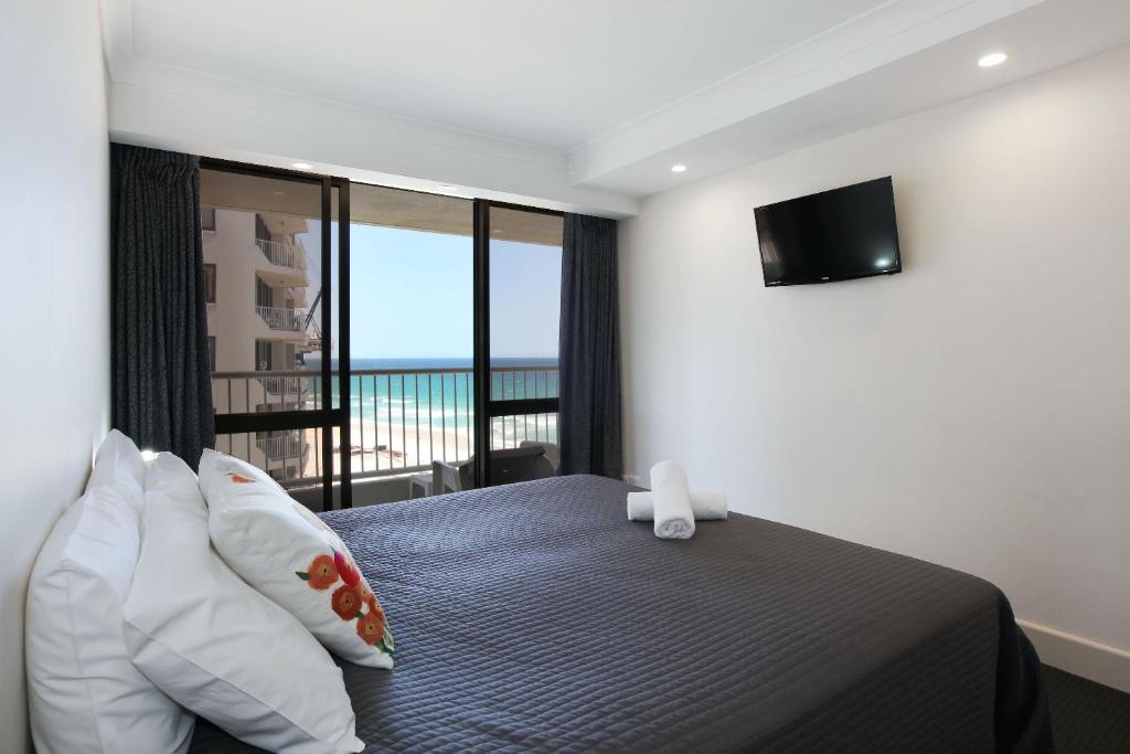 a bedroom with a bed with a view of the ocean at The Breakers in Gold Coast