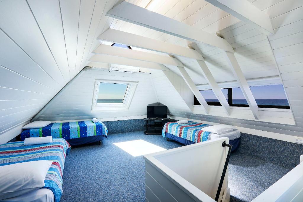 a attic room with two beds and a tv at The Breakers in Gold Coast