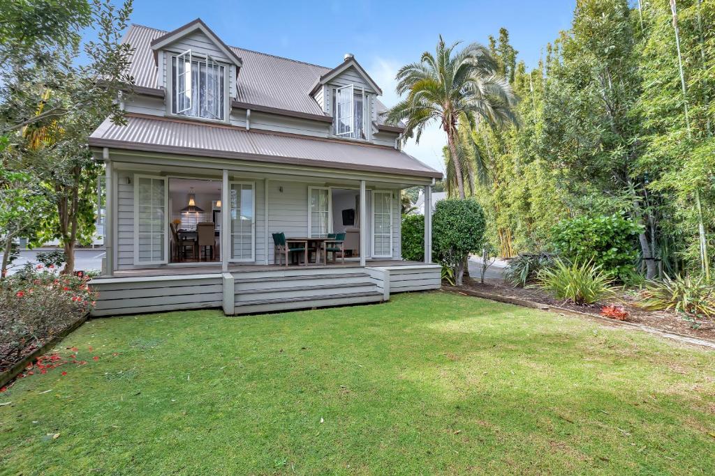 une petite maison blanche avec une cour dans l'établissement Russell Cottages - Russell Holiday Home, à Russell