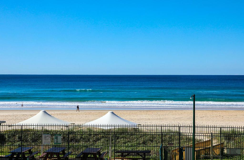 two white tents on a beach next to the ocean at The Breakers in Gold Coast