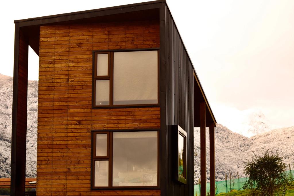 una casa con ventanas en un lateral en Alto Pangal Lodge Puerto Aysen, en Puerto Aysén