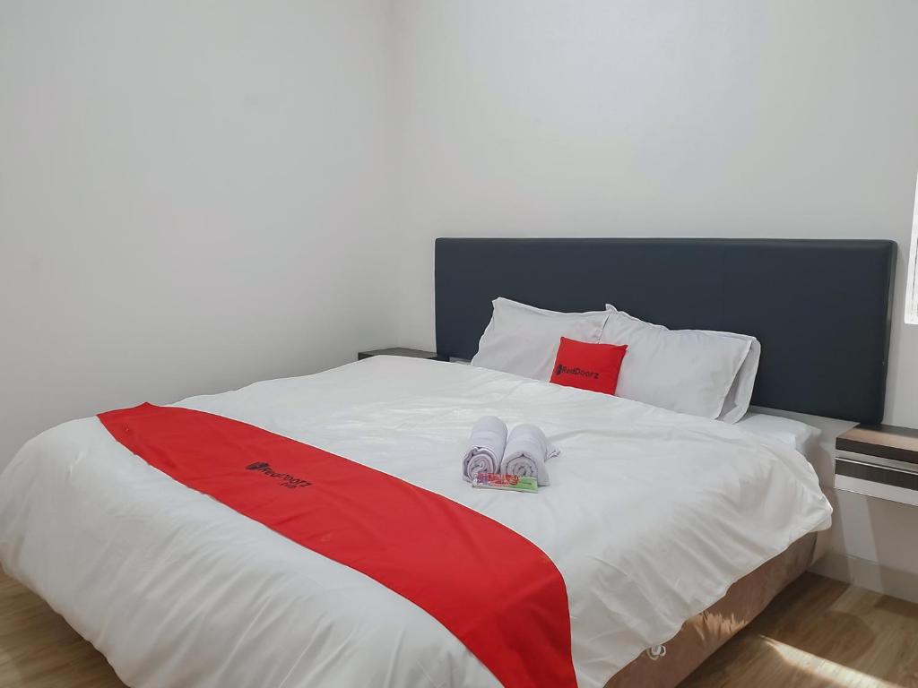 RedDoorz near Istana Plaza 3 في باندونغ: سرير عليه نعالين