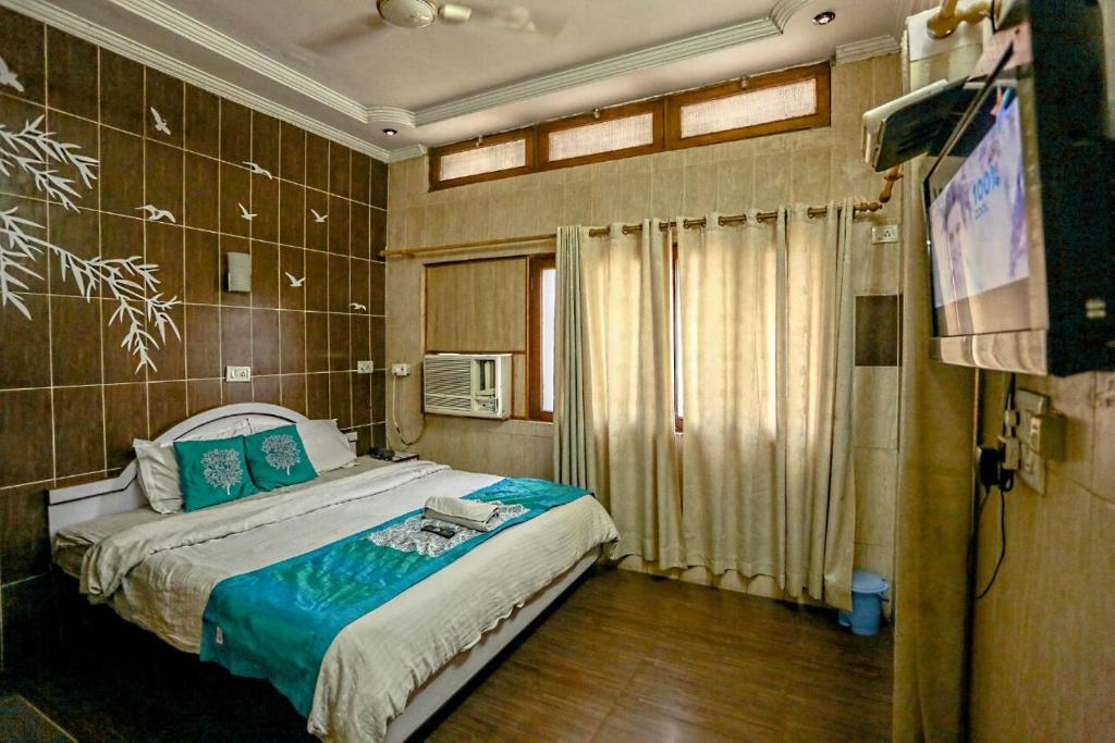 1 dormitorio con 1 cama y TV en The Trekkers Hostel - Dehradun, en Dehradun