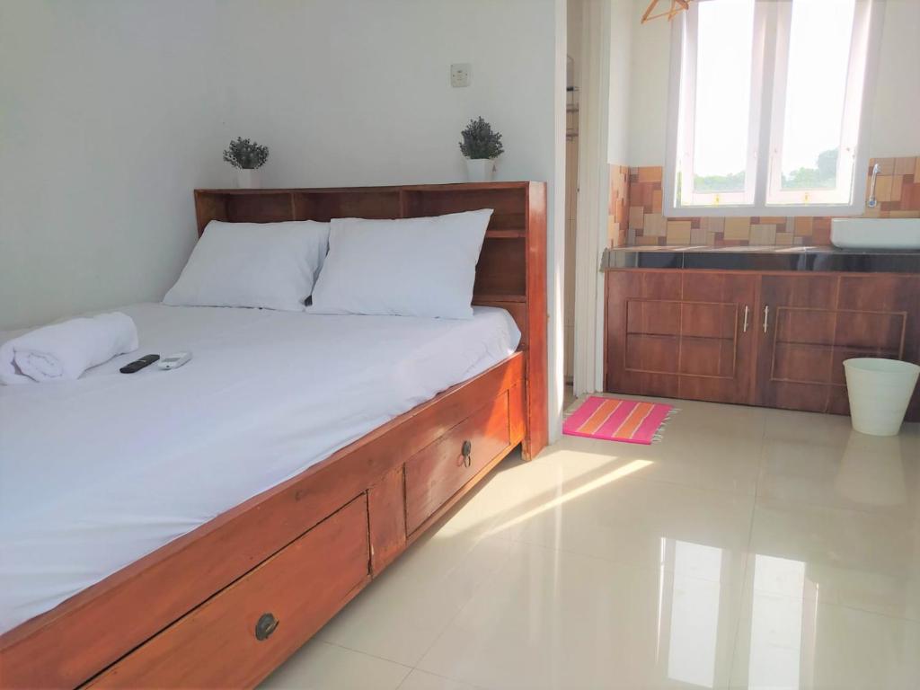 a bedroom with a large bed with a wooden frame at Guesthouse Berlian Batang Syariah near Kampung Kalisalak Park in Pekalongan