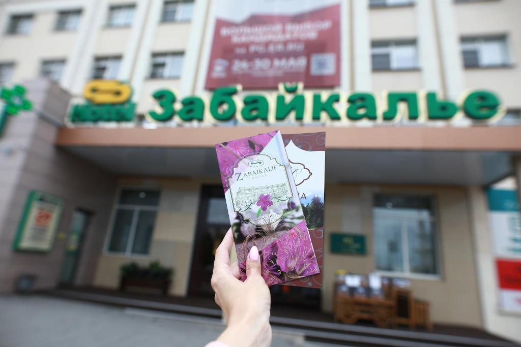 a person holding up a kite in front of a store at Hotel Zabaykalie in Chita