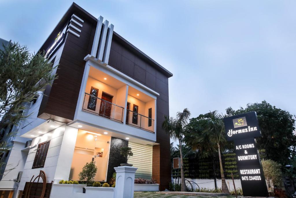 a building with a sign in front of it at Thenmala Hormuz Inn in Kolattupuzha