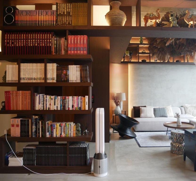 una sala de estar con una estantería llena de libros en W house en Hualien