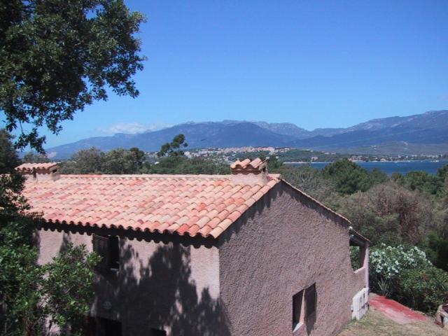 una casa con un techo de baldosas rojas encima en Locations A Suara, en Porto Vecchio