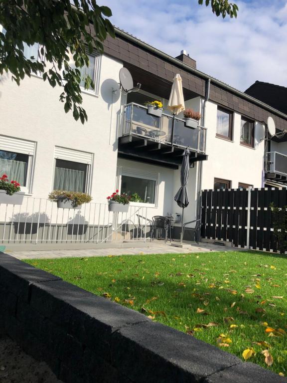 a white house with a balcony and a lawn at Ferienwohnung Lahntal Limburg in Limburg an der Lahn