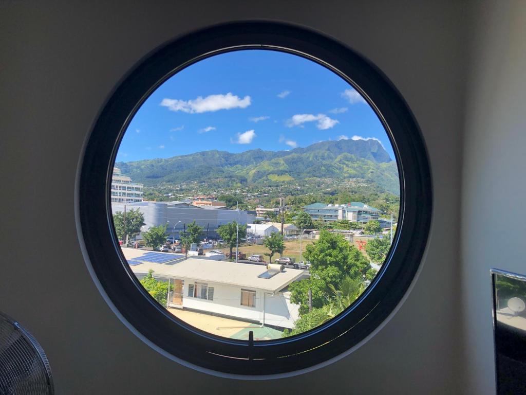 a round window with a view of a city at Standing Residence Tevai in Papeete