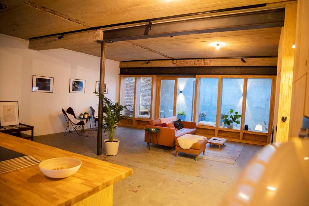 Studio73, Guesthouse met sauna في كورتريك: غرفة معيشة مع أريكة وكراسي ونوافذ