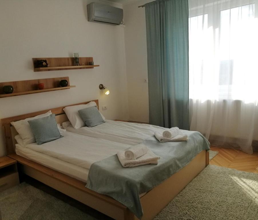 a bedroom with a large bed with towels on it at Check-In Kaya in Sibiu