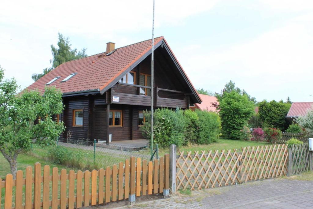 LoissinにあるHolzblockhaus mit Kamin am Kite , Surf und Badestrandの前に柵を持つ木造家屋