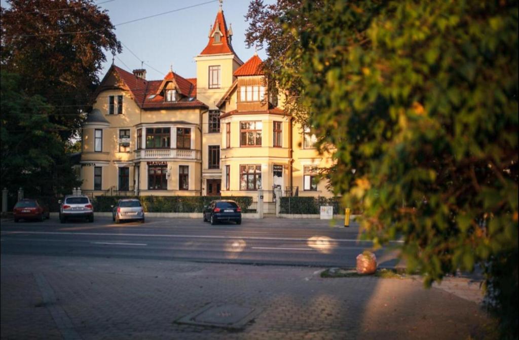 a large building with cars parked in front of it at Sopot Retro Apartment in Sopot