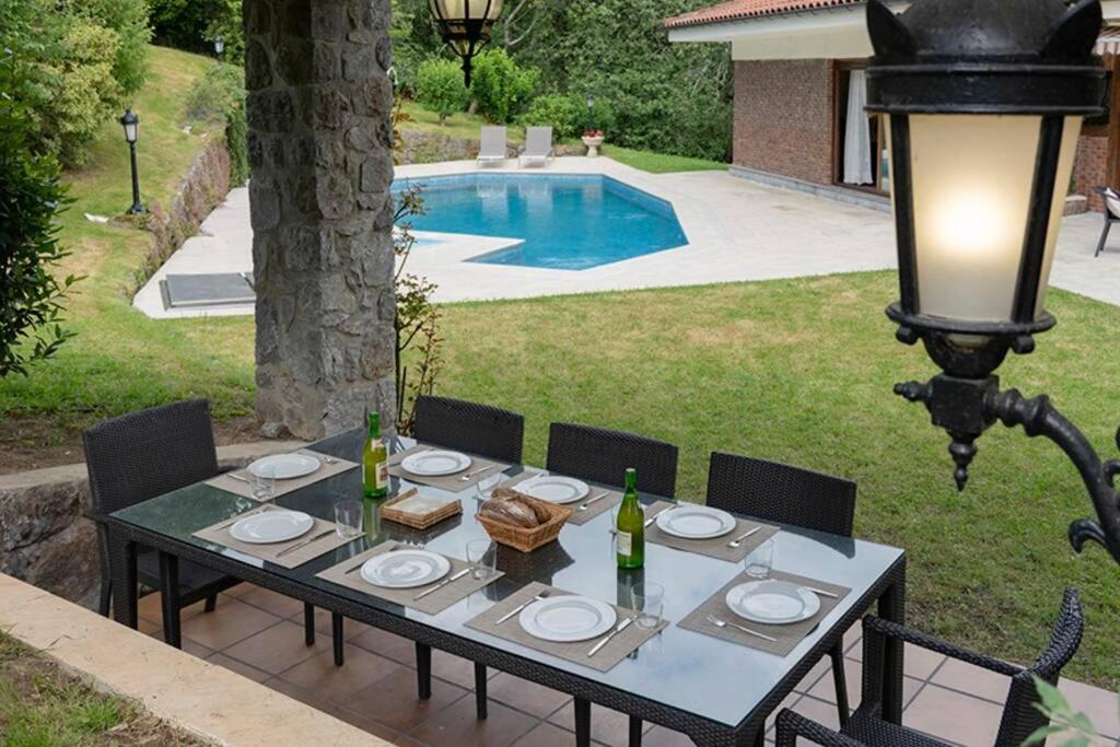 una mesa con platos y botellas de vino encima en Casa Rural Oroimena, en Andoain