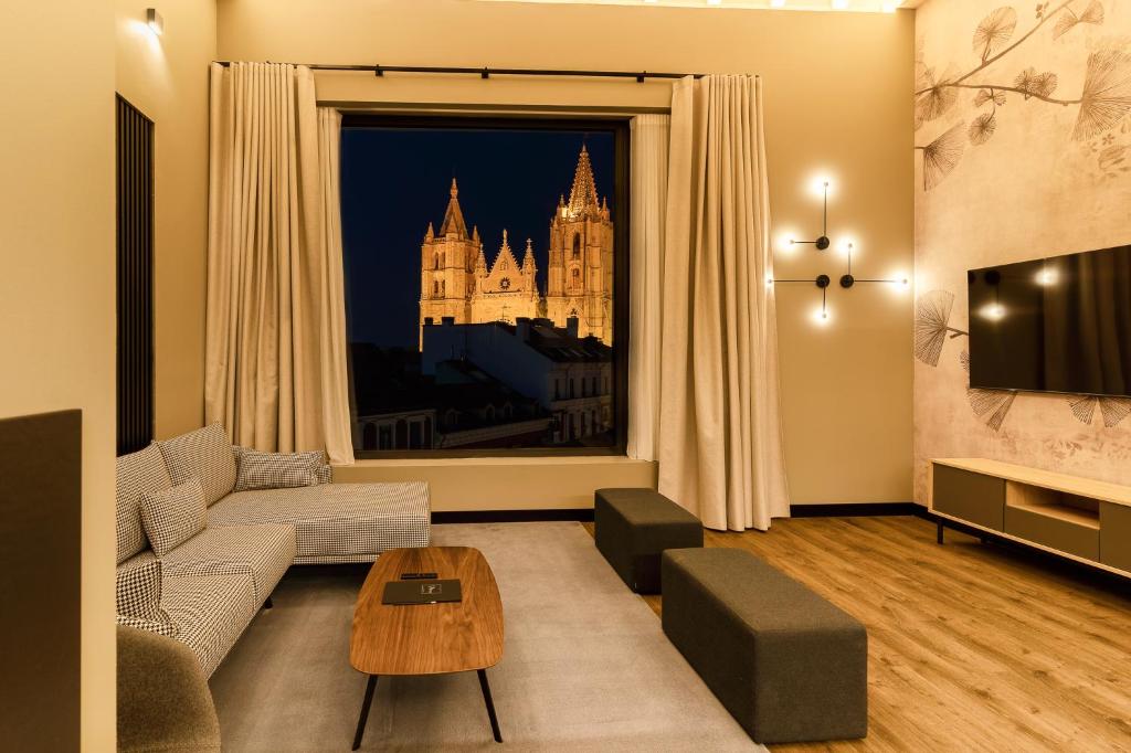 a living room with a couch and a large window at Mauro Suites in León