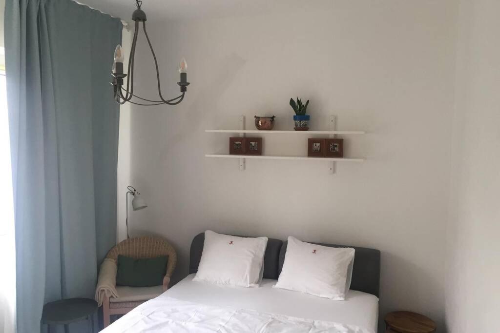 a bedroom with a bed with white sheets and a chair at A Cozy Studio in the City Centre in Bratislava