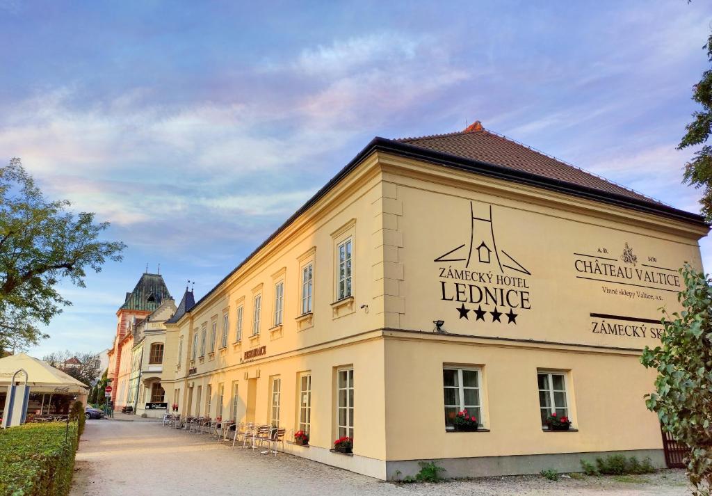 duży żółty budynek z napisem w obiekcie Zamecky Hotel Lednice w mieście Lednice