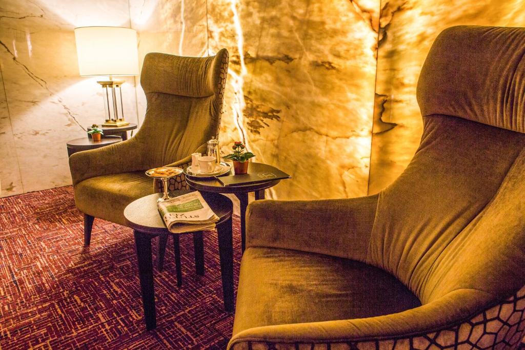 斯圖加特的住宿－皇家酒店，客厅配有两把椅子和一张桌子