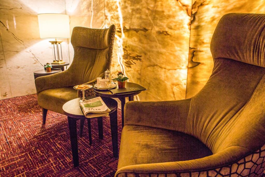 ein Wohnzimmer mit 2 Stühlen und einem Tisch in der Unterkunft Hotel Royal in Stuttgart