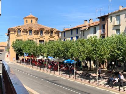 een straat met bomen en mensen aan tafel bij Casa Grande in Villarroya de la Sierra