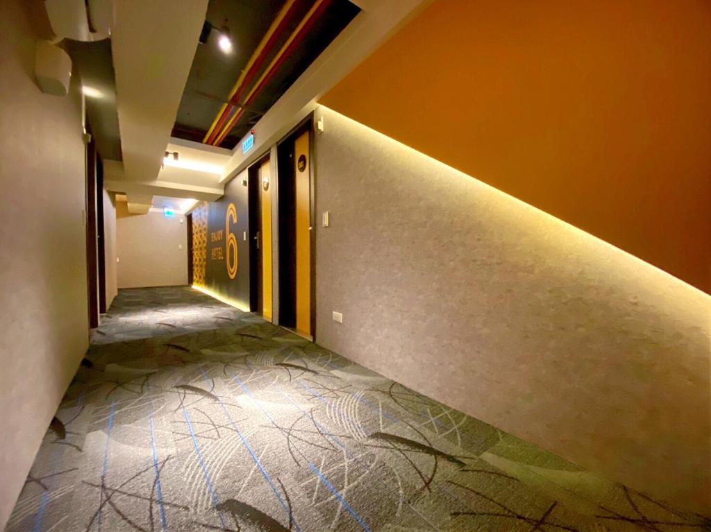 an empty hallway with a tile floor in a building at Hotel 6 - Ximen in Taipei