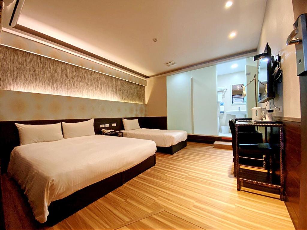 a hotel room with two beds and a television at Hotel 6 - Ximen in Taipei