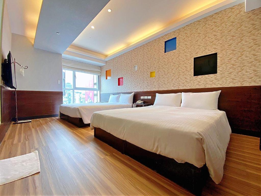 a hotel room with two beds and a television at Hotel 6 - Ximen in Taipei