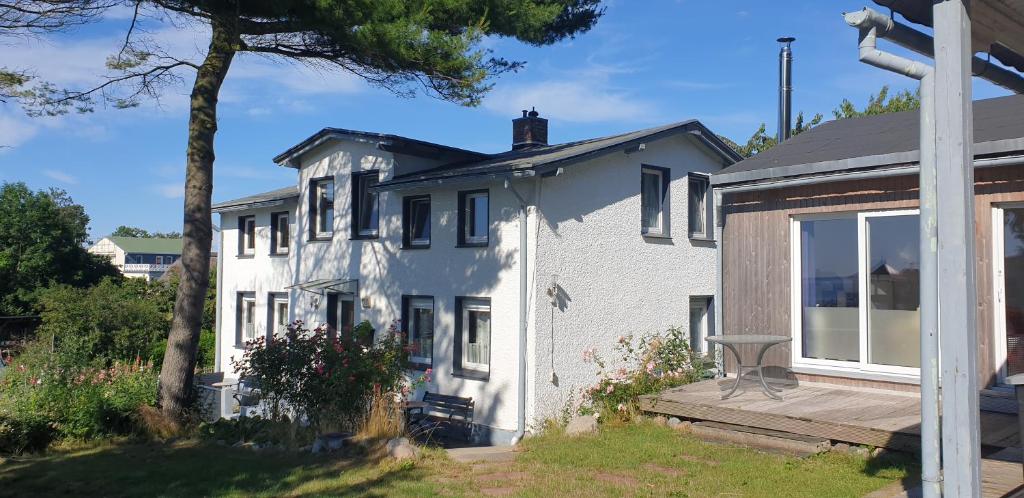 una casa bianca con portico e terrazza di Haus Ostseeblick a Lohme